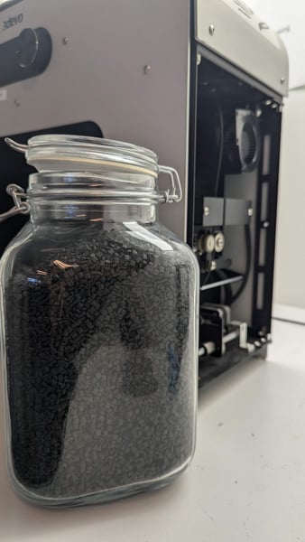 Carbon Fiber pellets next to a Filament Maker