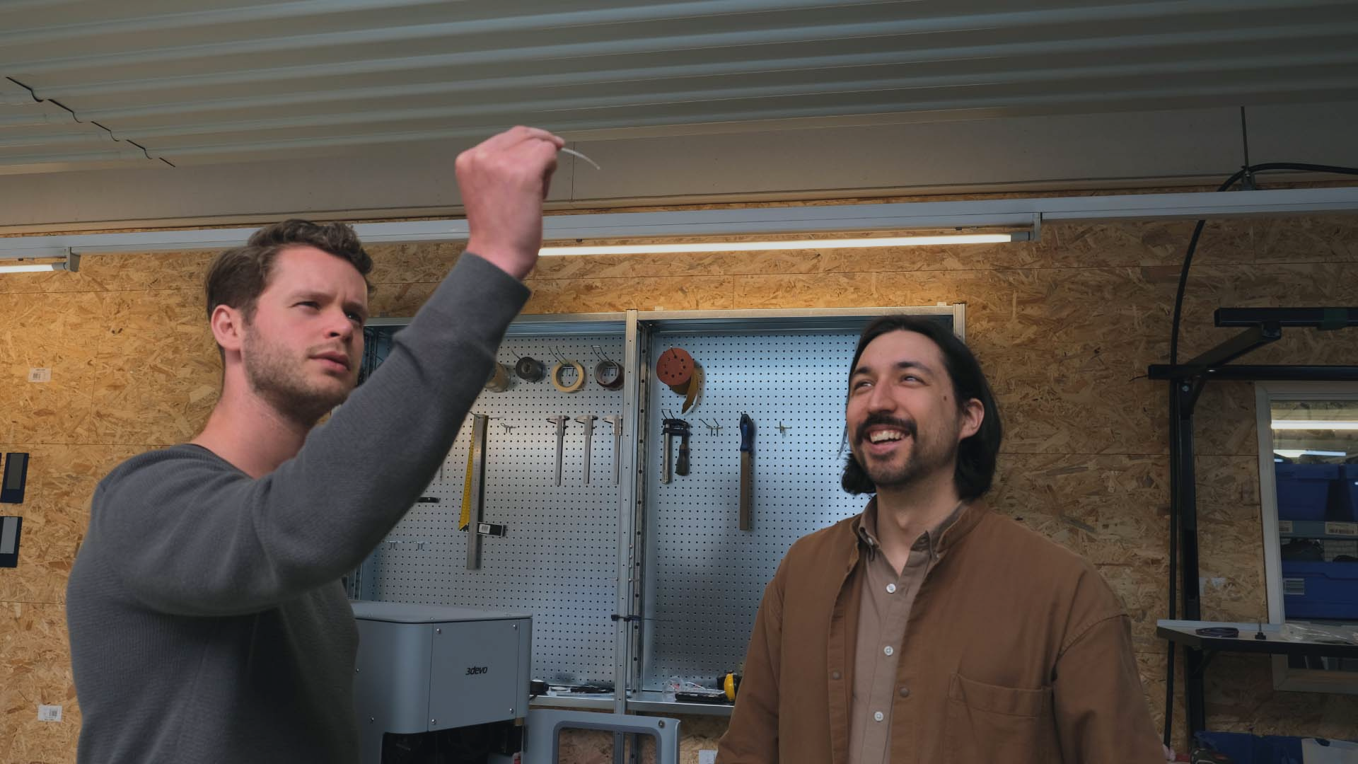 Engineers looking at an extruded filament in a fablabs setting